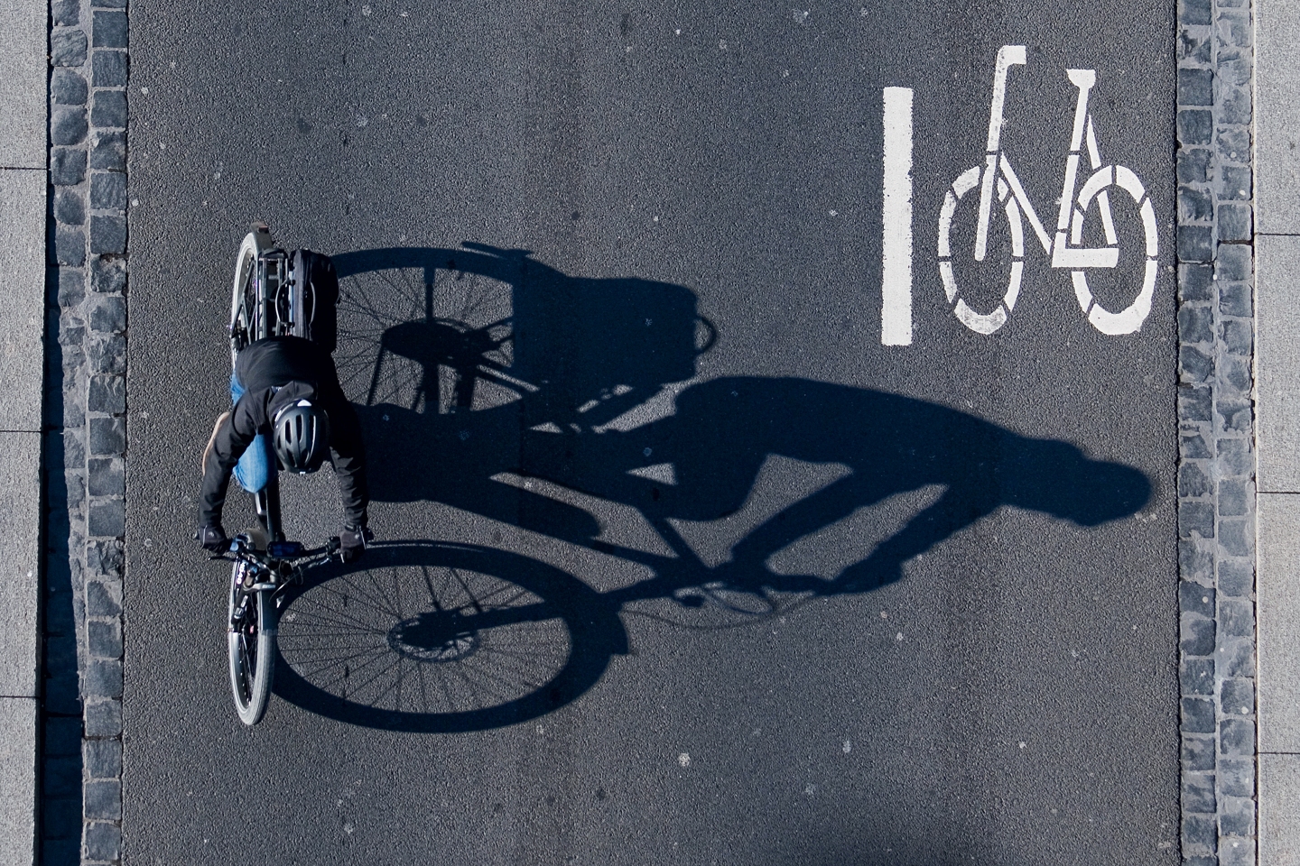 An e-bike cyclist rides a bike on a street.