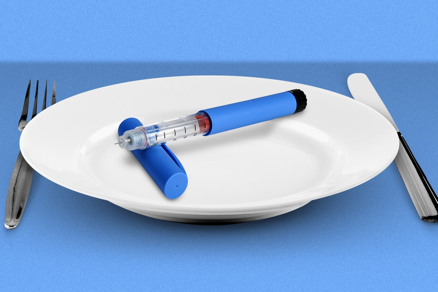 Photo illustration of a diabetes pen sitting on a white dinner plate with a fork and knife on either side.