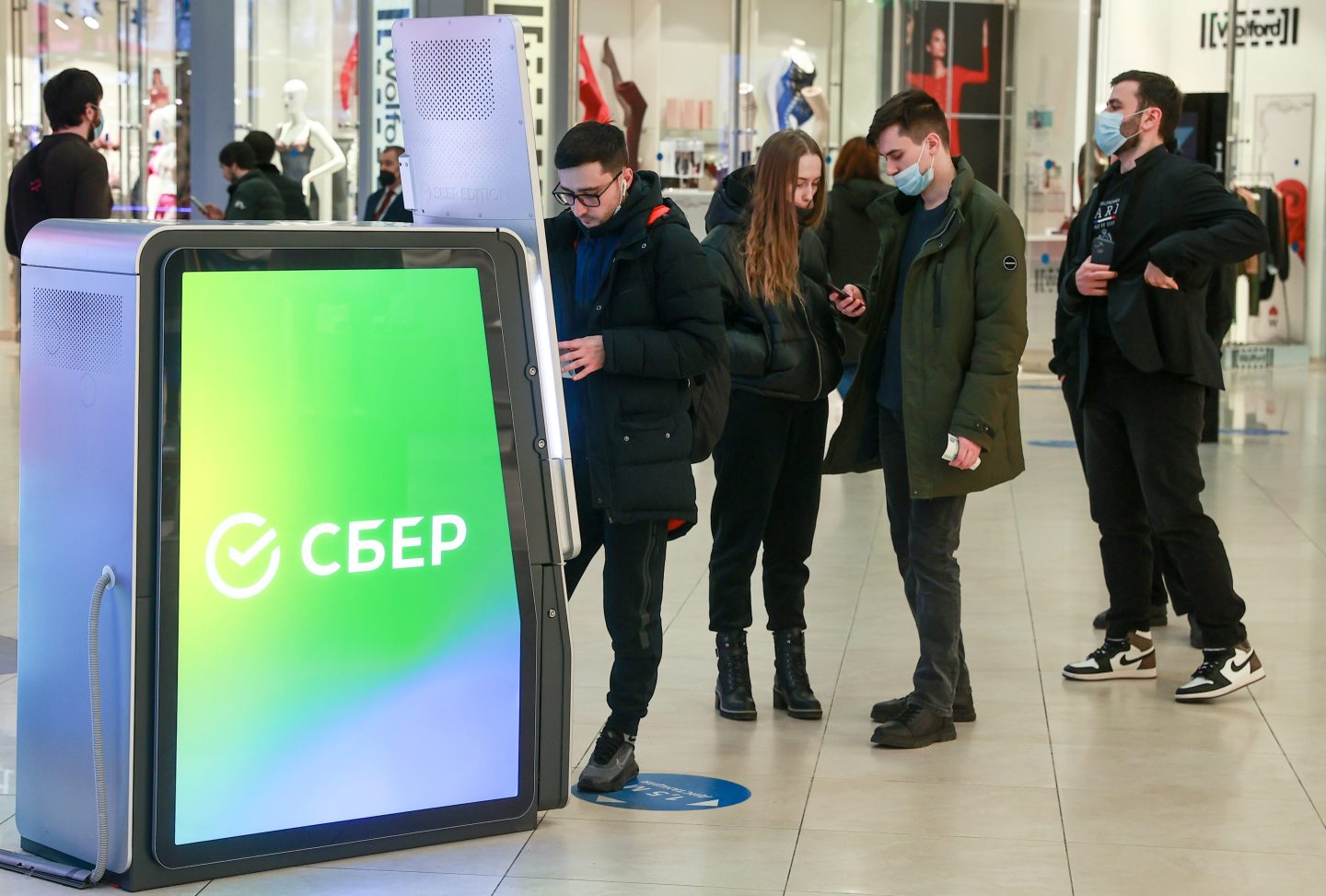 Russians line up to use an an ATM in a Russian mall