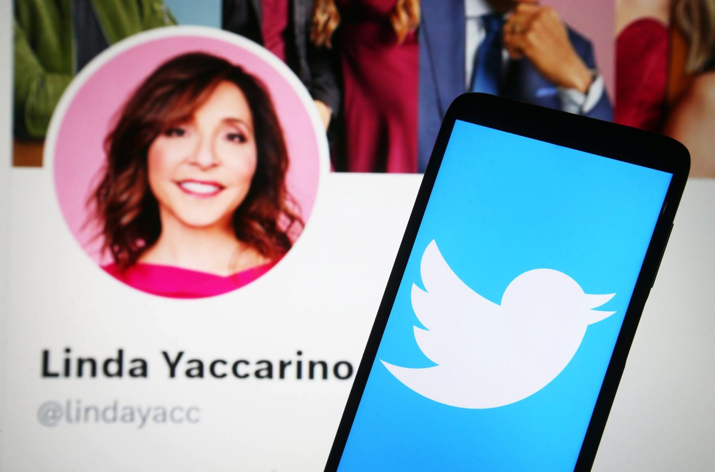 a Twitter logo is seen on a smartphone and Linda Yaccarino Twitter webpage on a pc screen