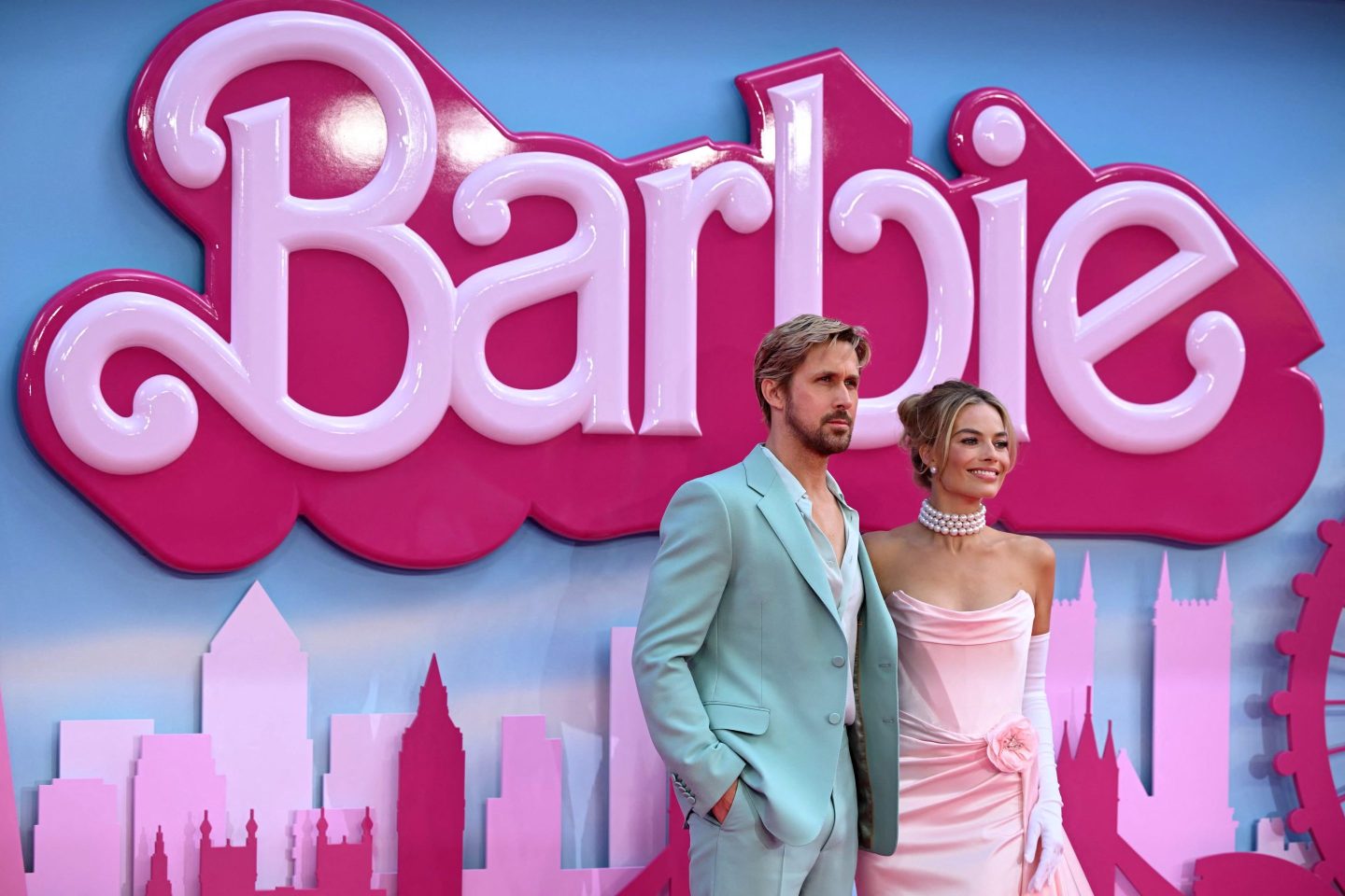 male and female actors posing in front of pink "Barbie" sign