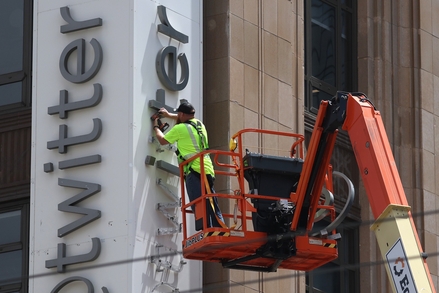 A worker removes letters from the Twitter sign that is posted on the exterior of Twitter headquarters on July 24, 2023, in San Francisco