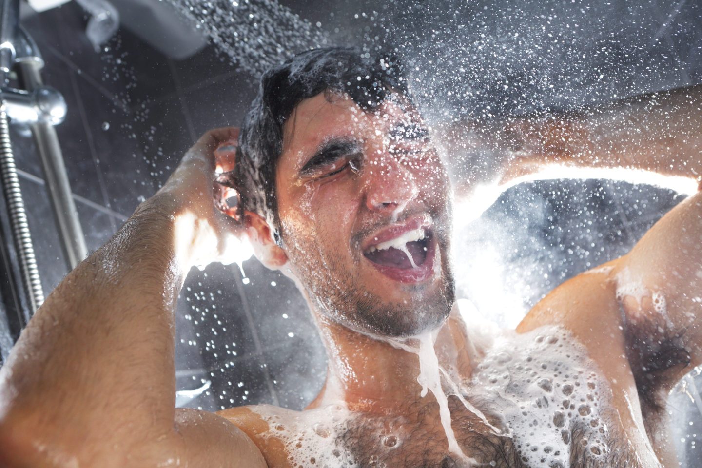 Man in shower, rinsing shampoo from hair