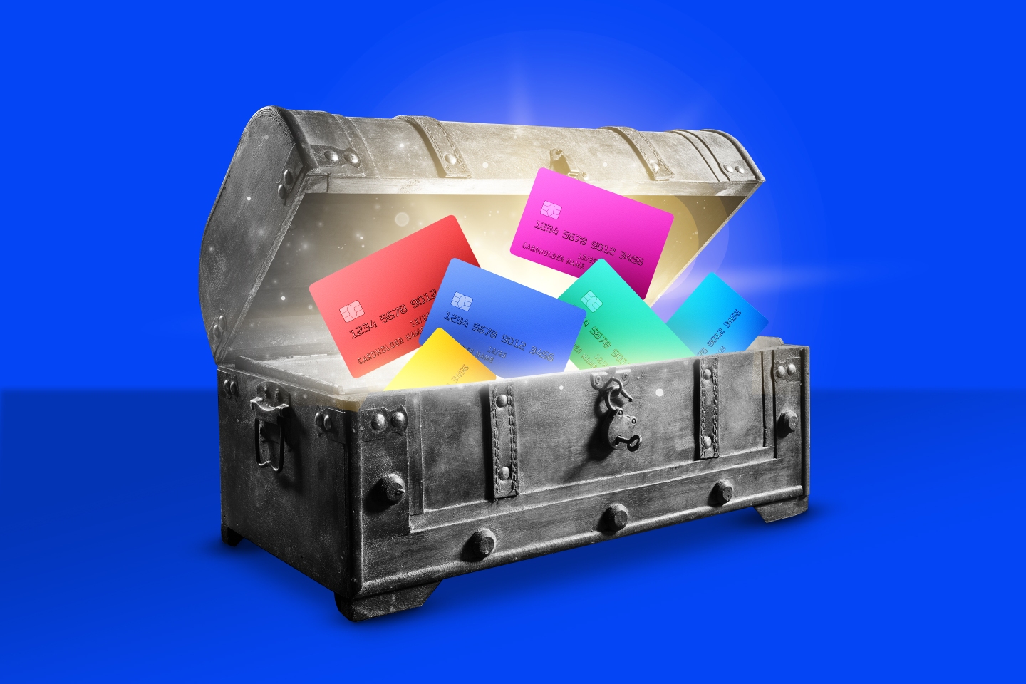 Photo illustration of a treasure chest with the top open, the inside glowing, and multi colored credit cards floating out of it.